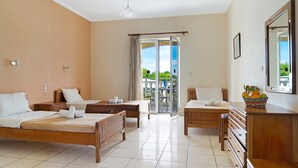 Ein Hotelzimmer mit zwei Betten, einem Schreibtisch, einem Schminktisch und einem Balkon mit Blick.