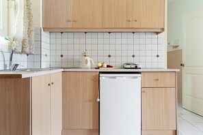 A kitchen with wooden cabinets, a white dishwasher, and a tiled backsplash.