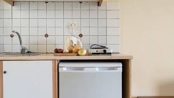Una cocina con un lavamanos, un tostador y un lavavajillas.