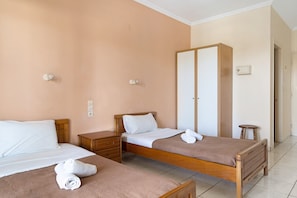 A hotel room with two single beds, a wooden wardrobe, a bedside table, and a small stool. - Studio 'Sandy Maria Studio 601' with Shared Pool, Wi-Fi (Zante)