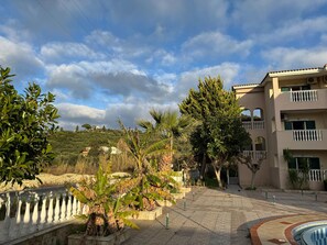 A residential area with a paved walkway, a pool, and a building with balconies.