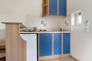 A kitchen with a dishwasher, a sink, and blue cabinets.
