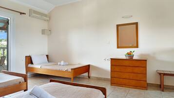 Une chambre avec deux lits, une commode, un miroir et un appareil de climatisation.