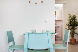 A dining area with two light blue chairs, a round table, and a potted plant. - Vacation Home '4ever2 (copy)' with Wi-Fi and Air Conditioning (Corralejo)
