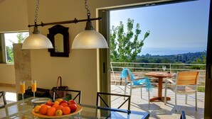 Un comedor con una mesa dispuesta para dos, un frutero y vistas al exterior.