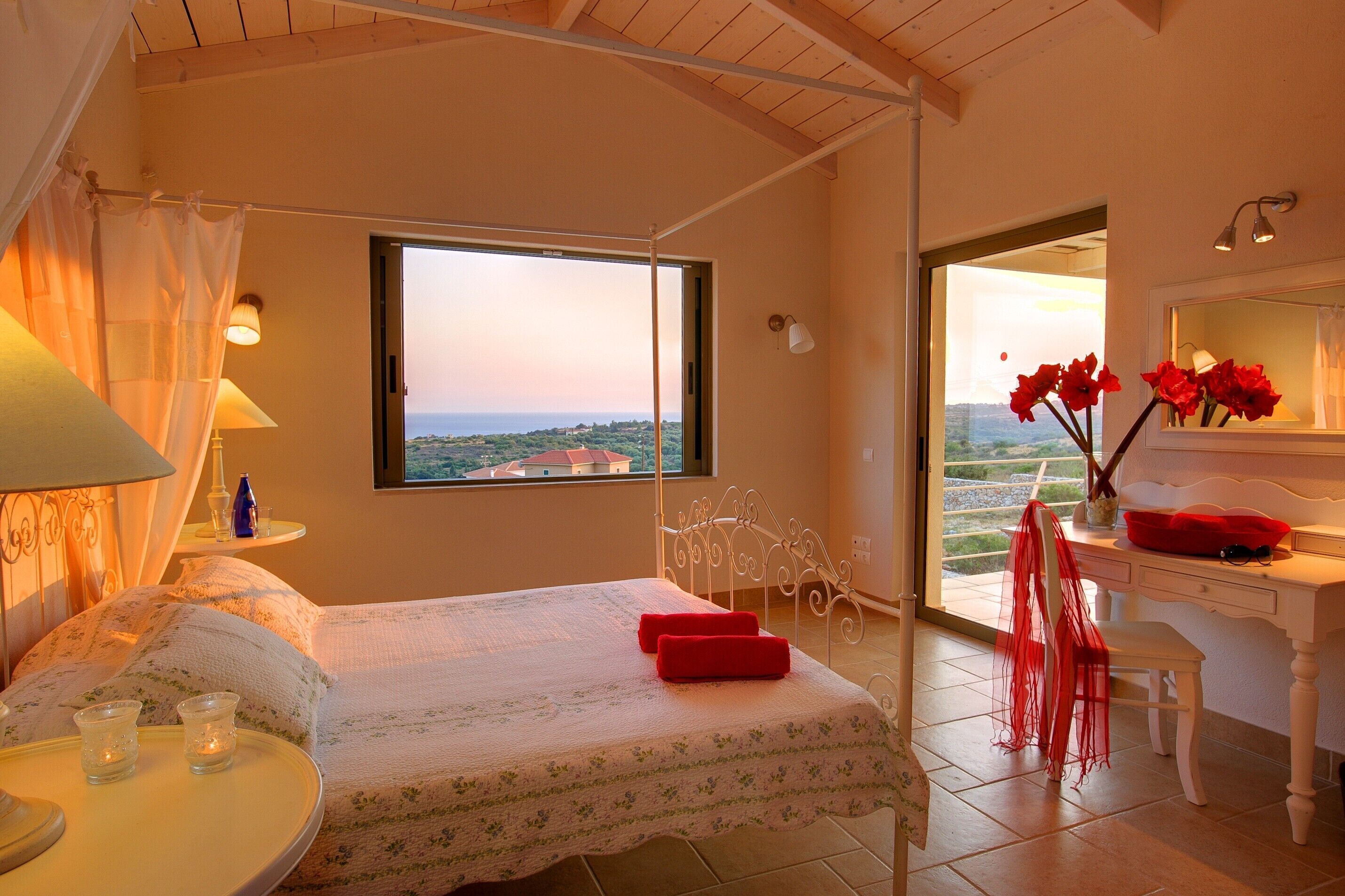 Une chambre à coucher comprenant un lit, un bureau, une chaise, une fenêtre avec vue et une salle de bain.