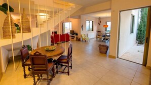 A spacious living area with a dining table, chairs, and a staircase. - Villa 'Corali Ideales Resort' with Sea View, Wi-Fi and Air Conditioning (kefalonia)