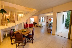 Un vaste espace de vie comprenant une table à manger, des chaises et un escalier.