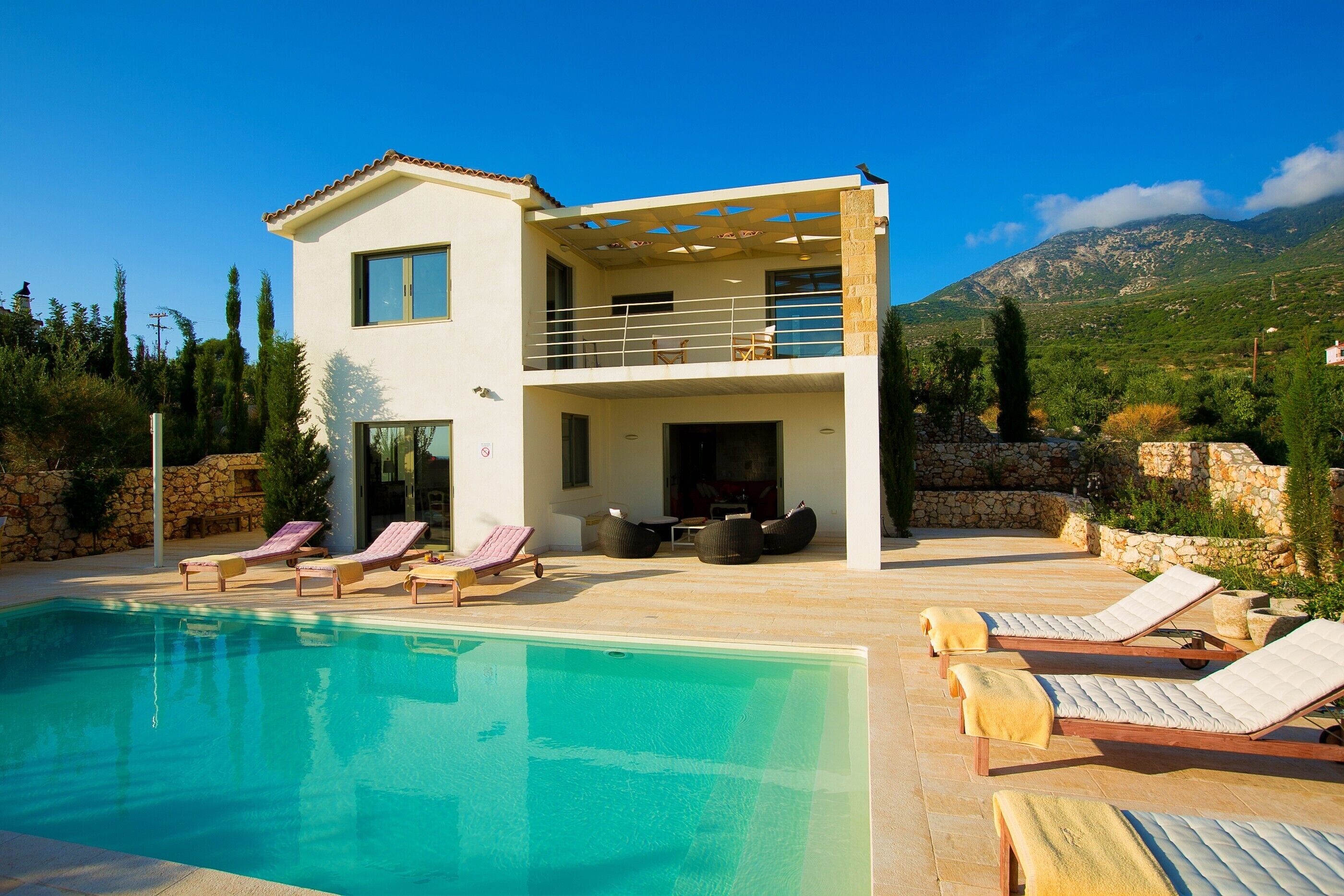 Ein zweistöckiges Haus mit Swimmingpool, Außenbereich und Bergblick.