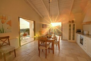 A dining area with a table, chairs, and a view of the outdoors.