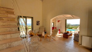 Ein geräumiger Wohnbereich mit Treppe, Meerblick und Pool.