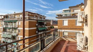 A residential building with multiple balconies, a brick facade, and a clear blue sky.