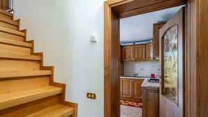 Eine Holztreppe führt zu einer Küche mit Holdekor und einer gefliesten Spritzschutzwand.