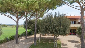 Il s’agit d’une propriété dotée d’une allée gravillonnée, d’un jardin clos et d’un bâtiment dont le toit est recouvert de tuiles rouges.