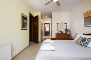 Una habitación de hotel con cama, cómoda, espejo y ventilador de techo.