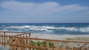 A beach with waves, a wooden fence, and a clear sky. - Villa 'Maria' with Sea View, Private Terrace and Wi-Fi (Cala Liberotto)