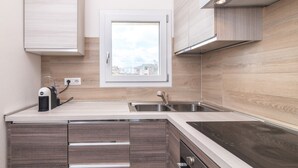 A modern kitchen with a window, built-in cabinets, a sink, and a stove.