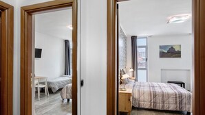 Une chambre d’hôtel avec un lit, une table de chevet, une lampe et un tableau au mur.