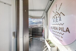 Entrada de hotel con vistas a montañas y un letrero que dice Alpen Pila.