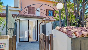 A narrow pathway leading to a building with a tiled roof, a wooden gate, and a lamp post. - Vacation Home "Sea Wave House" with Private Garden and Wi-Fi (San Teodoro)