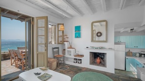 A room with a view of the sea, a fireplace, and a kitchen area. - Holiday Home 'Karavi' with Private Terrace, Balcony and Air Conditioning (S???f??)