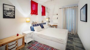 Une chambre bien rangée, avec un lit, des tables de chevet, un bureau et une chaise.