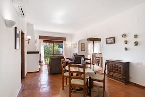 A dining area with a round table, chairs, and a wooden cabinet.