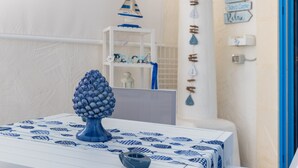 A room with a bed, a blue and white patterned tablecloth, a blue vase, a lamp, and a wall with directional signs. - Holiday Apartment "Home Borgo Rio Favara" with Private Terrace & Wi-Fi (Ispica)