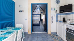 A kitchen with a TV, a coffee maker, and a tiled backsplash. - Holiday Apartment "Home Borgo Rio Favara" with Private Terrace & Wi-Fi (Ispica)
