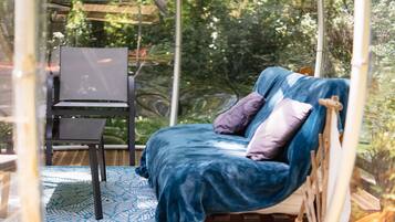A bed with a blue blanket and pillows, a chair, and a patterned rug.