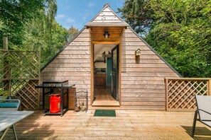 Eine Holzhütte mit Satteldach, einer Tür und einer kleinen Veranda.