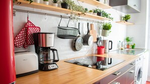 A modern kitchen with a coffee maker, toaster, and a washing machine.