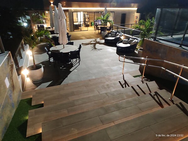 A modern outdoor patio area with a staircase leading to an upper level.