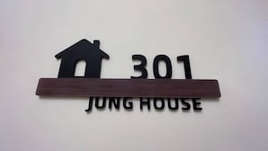 Un letrero con un icono de casa y el número 301, que indica 'JUNG HOUSE'.