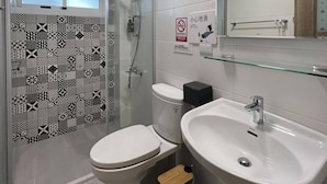 Un baño moderno con ducha, inodoro y lavamanos.