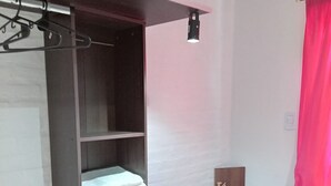 A compact room with a built-in wardrobe, a small desk, and a shower area. - Consorcio General Acha ,apartamentos (San Juan)