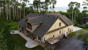 A two-story house with a large porch, a garage, and a driveway. - Family Lodge in Beautiful Star Valley (Star Valley Ranch)