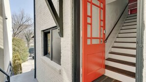 A white brick building with a red door, a window, and a staircase. - Sleeps 8 Historic loft near 12 South with easy access to local attractions (Nashville)