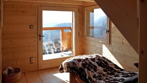 A wooden cabin room with a bed, a window, and a door. - Gorgeous home in Onnion with WiFi (Onnion)