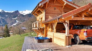 A wooden chalet with a hot tub and a vehicle parked outside. - Gorgeous home in Onnion with WiFi (Onnion)