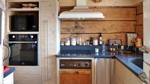 A compact kitchen with wooden walls, a built-in oven, a dishwasher, and a stove. - Gorgeous home in Onnion with WiFi (Onnion)