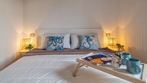 A bedroom with a bed, pillows, bedside tables, and a tray with a magazine and mugs. - Vacation home Momo by Interhome (Valledoria)