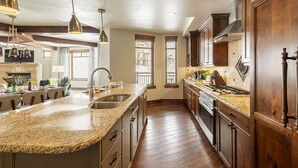 A spacious kitchen with granite countertops, wooden cabinets, and a large island with a sink. - Luxury Amenities in Canyons!  Ski-in/Ski-out, Amenities, In-room dining (Park City)