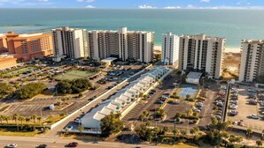 A high-rise hotel with multiple floors, a parking lot, and a view of the ocean. - Perdido Dunes 30 2/2 sleeps 6 (Orange Beach)