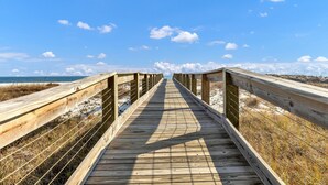 A wooden boardwalk leading to a beach with a clear sky and distant clouds. - Perdido Dunes 30 2/2 sleeps 6 (Orange Beach)