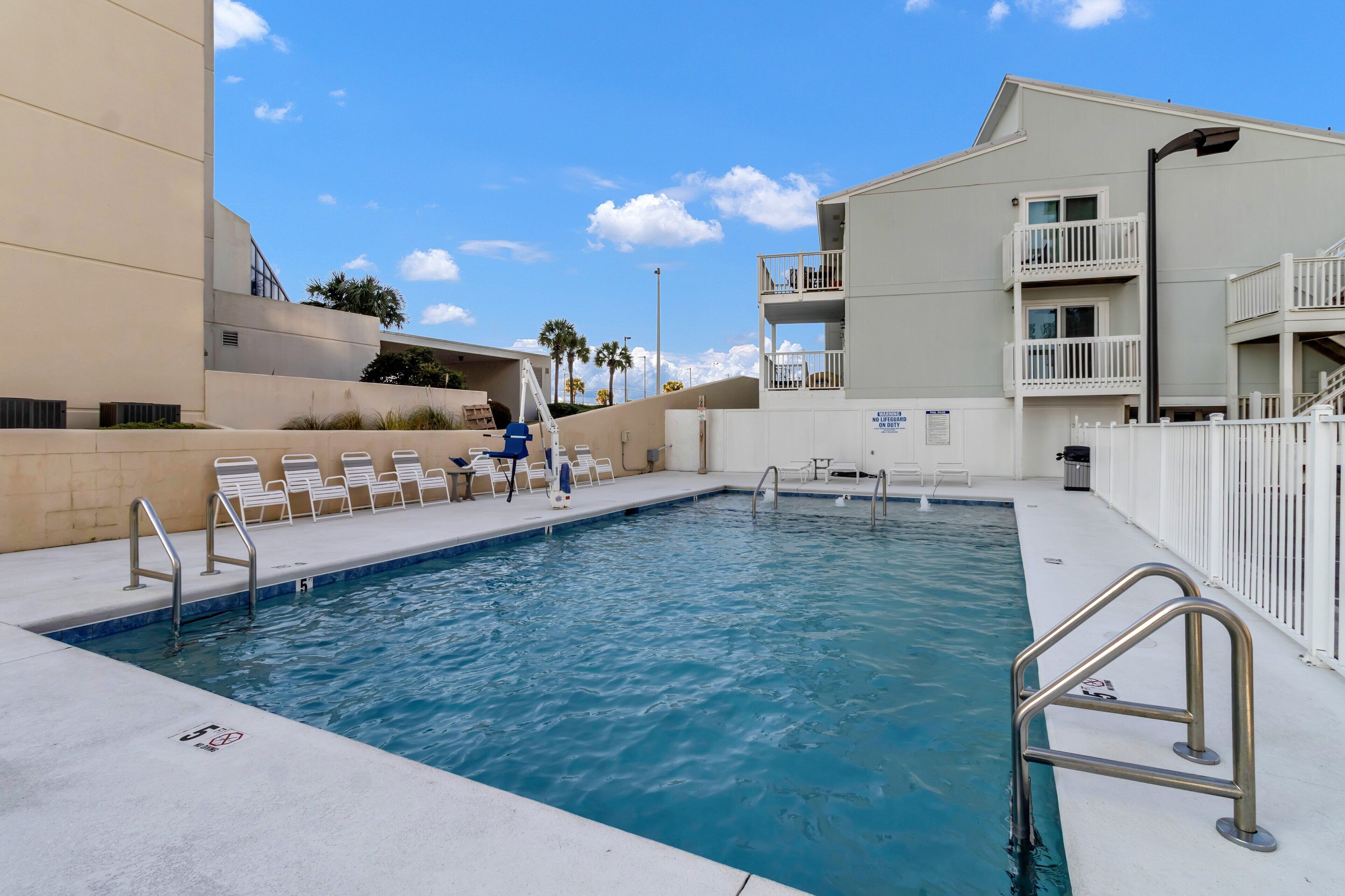 A swimming pool with lounge chairs and a staircase leading to an upper level.