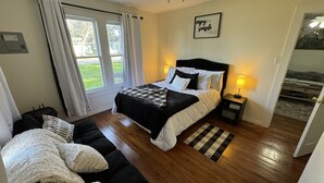 A bedroom with a bed, a nightstand, a window with curtains, a ceiling fan, and a motivational quote on the wall. - Cozy Retreat in Geronimo w/ 2 BD (Seguin)