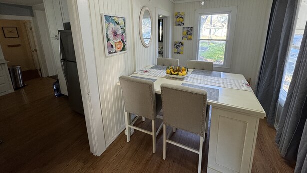 A kitchen with a dining area, white wooden walls, a ceiling fan, and a window with curtains. - Cozy Retreat in Geronimo w/ 2 BD (Seguin)