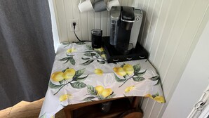 A small coffee station with a coffee maker, mugs, and a sign that says "COFFEE". - Cozy Retreat in Geronimo w/ 2 BD (Seguin)