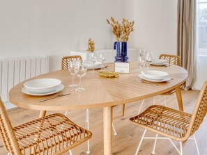 Enjoy meals in this cozy dining area with a round table and four chairs, set with fine china and wine glasses.